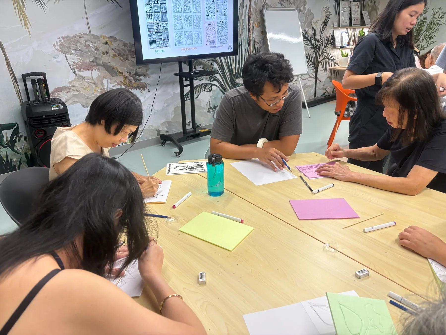 Participants working on individual printmaking designs in a facilitated group session