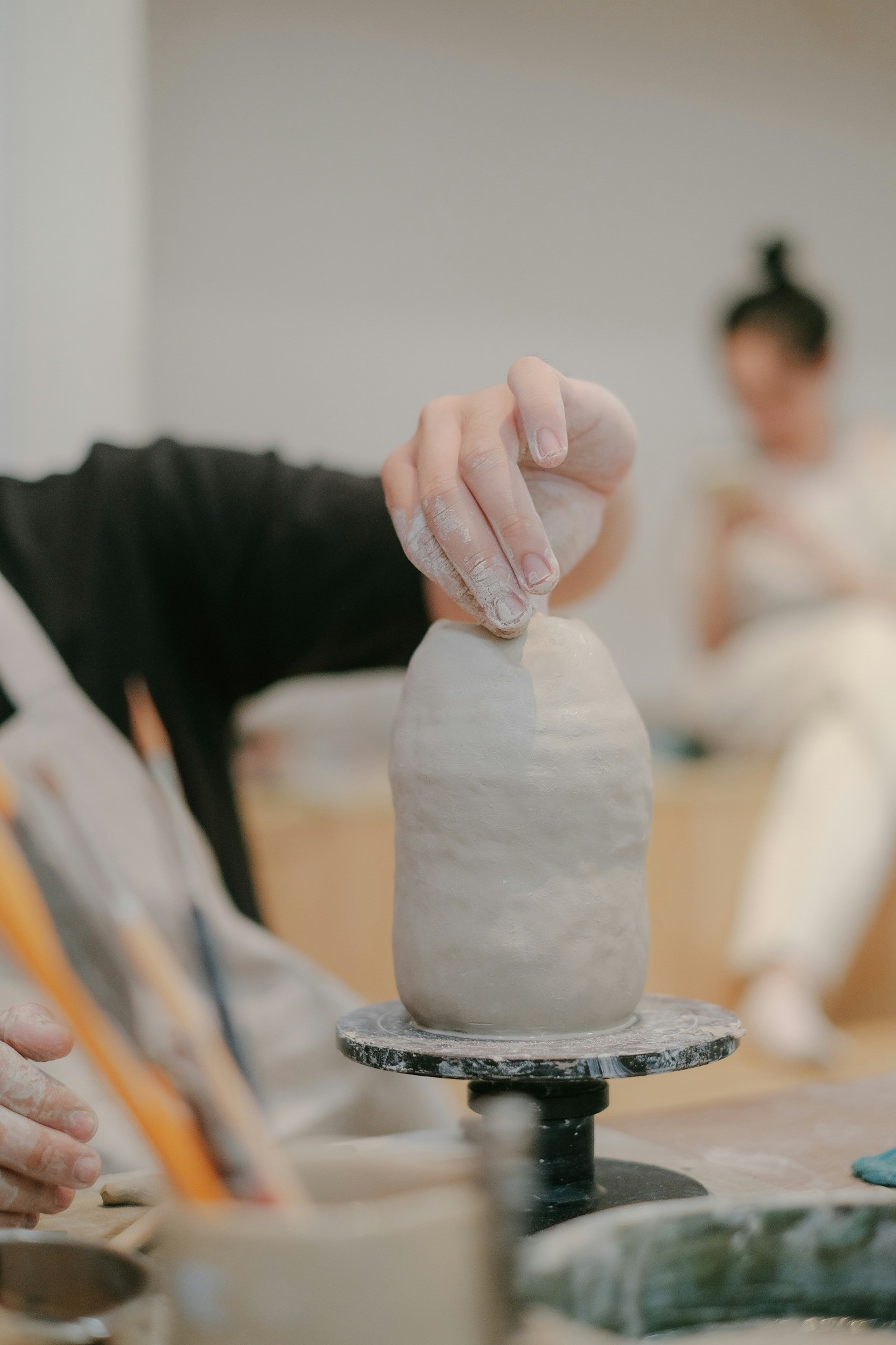 Hands shaping a clay piece during a ceramics workshop
