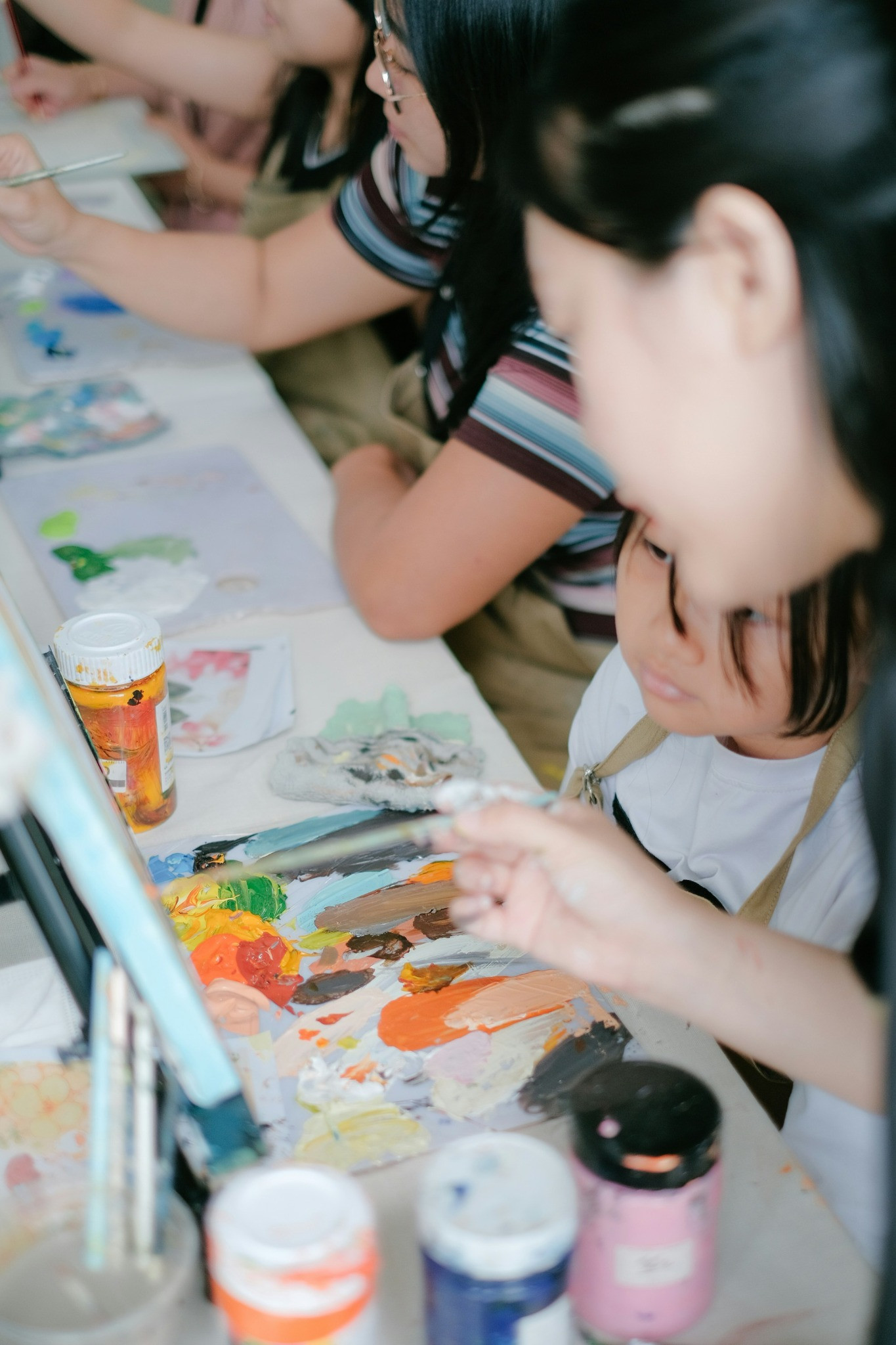 A child painting with guidance at an art workshop