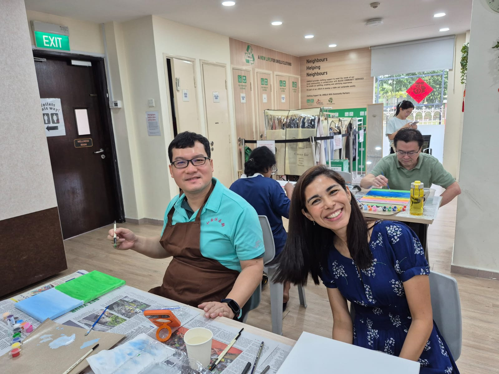 Participants smiling and presenting completed paintings