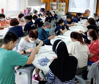 A large group of people participating in a guided creative workshop